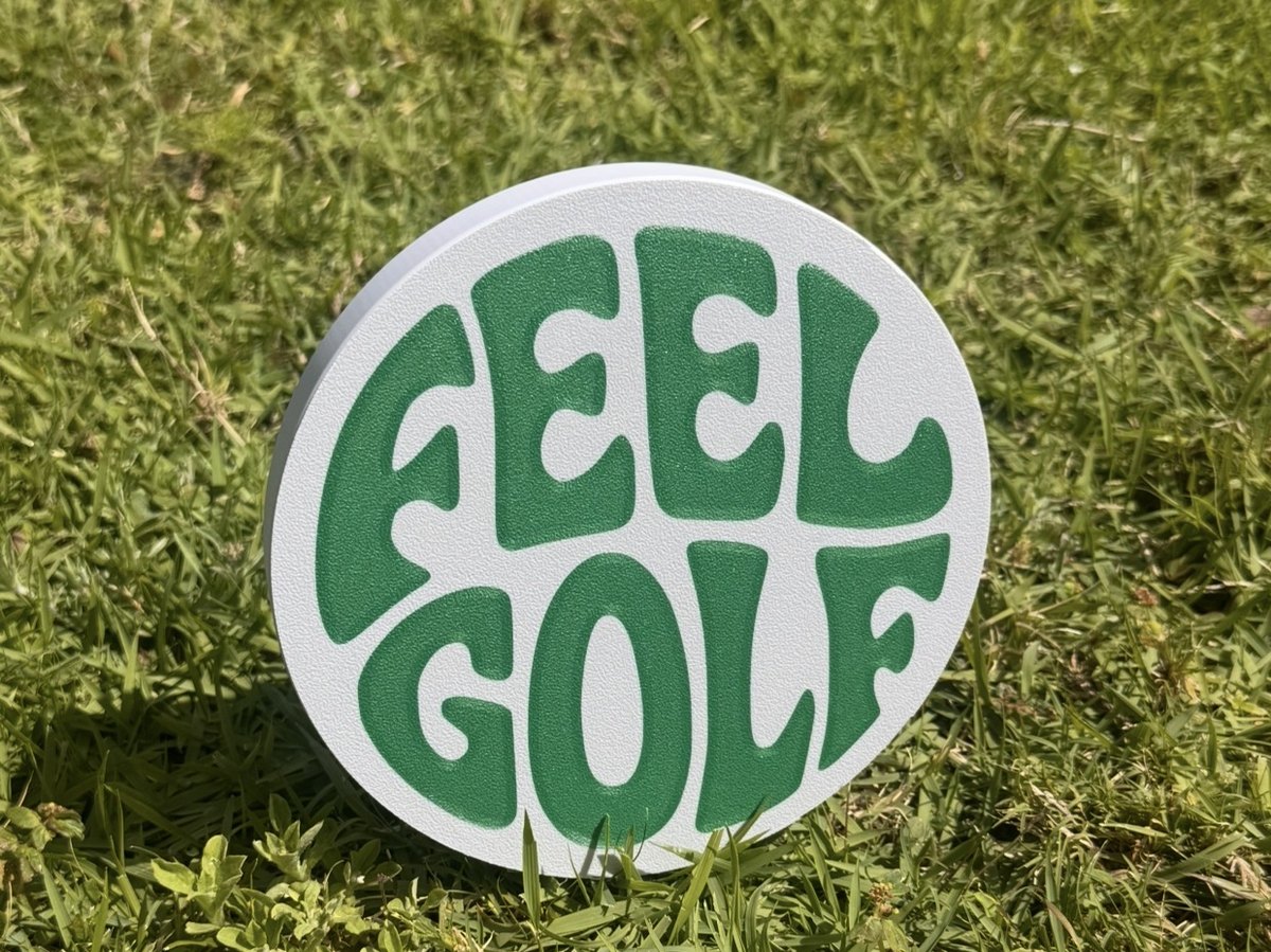 FEEL GOLF roundel marker standing in tee-box grass