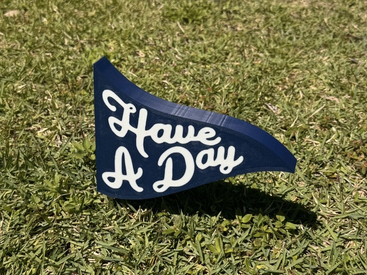 Have A Day pennant marker staked in tee-box grass