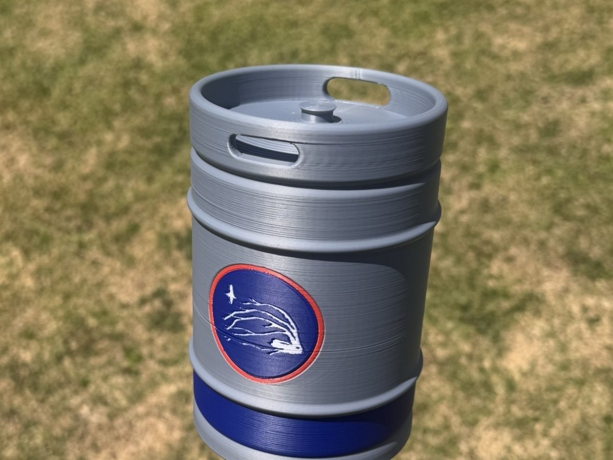 Keg-shaped sponsor marker with a crest, on a tee box